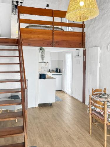 a room with a bunk bed and a table and a kitchen at Duplex au vert près de Royan - Appartement 4 in Médis