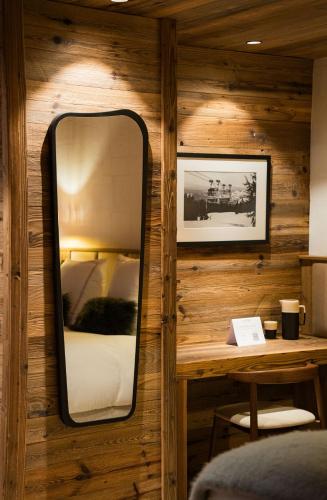 a mirror in a room with a bed and a table at Silverstone by Alpine Resorts in Val dʼIsère