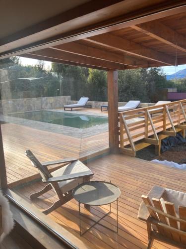 eine Terrasse mit einem Stuhl und einem Swimmingpool in der Unterkunft Casa Rincon Radales in San Martín de los Andes