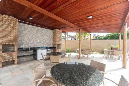 a patio with a table and chairs and a fireplace at Porto de Galinhas - Apartamento 3 quartos a 30m do mar in Porto De Galinhas