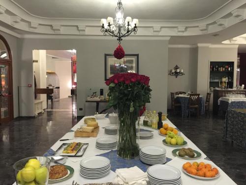 Hotel Corallo في مونتيكاتيني تيرمي: طاولة مع أطباق من الطعام و إناء من الزهور
