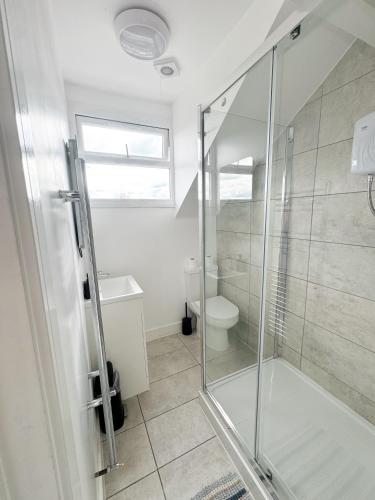a bathroom with a glass shower and a toilet at Modern 4 Bed En-suite House in Leeds - Free parking in Headingley
