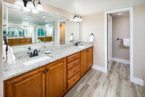 ein Badezimmer mit zwei Waschbecken und einem großen Spiegel in der Unterkunft Nautilus 1701 Gulf Front 2 Bedroom Large Penthouse Huge Wrap Around Balcony in Fort Walton Beach