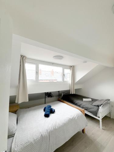 a bedroom with two beds and a window at Modern 4 Bed En-suite House in Leeds - Free parking in Headingley