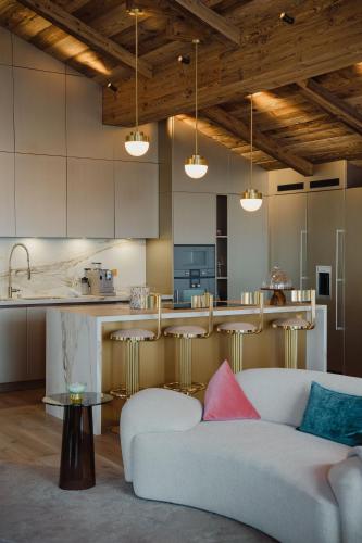 a living room with a couch and a kitchen at Silverstone by Alpine Resorts in Val dʼIsère
