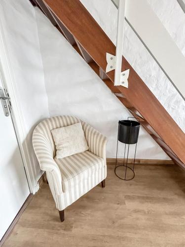 a living room with a chair in a attic at Douceur de vivre, calme et jardin Appartement 3 in Médis