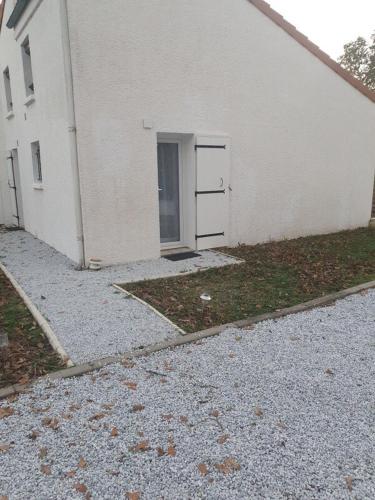 a white building with a door on the side of it at Douceur de vivre, calme et jardin Appartement 3 in Médis