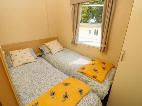 two beds in a small room with a window at Greenwood in Cowes