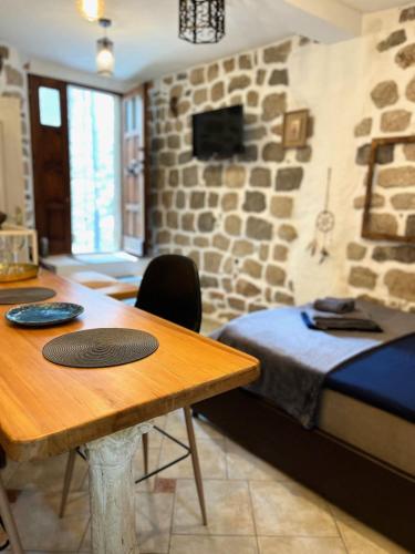 a room with a bed and a wooden table with a tableablish at HealthyStudio512 Apartments in Kotor