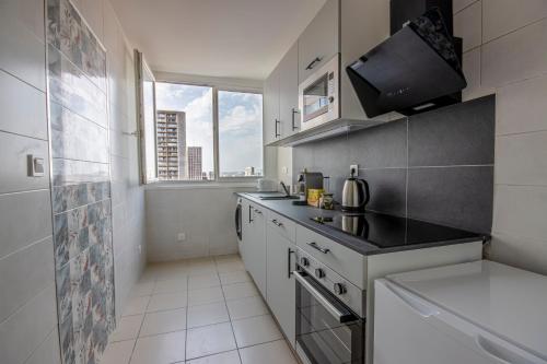 une cuisine avec un évier et une cuisinière four supérieur dans l'établissement Appartement cosy aux coeur de Paris - 10 pers, à Paris