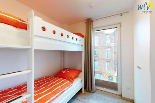 a bedroom with two bunk beds and a window at Haus Seeblick Ferienwohnung Nordseekieker in Wangerooge
