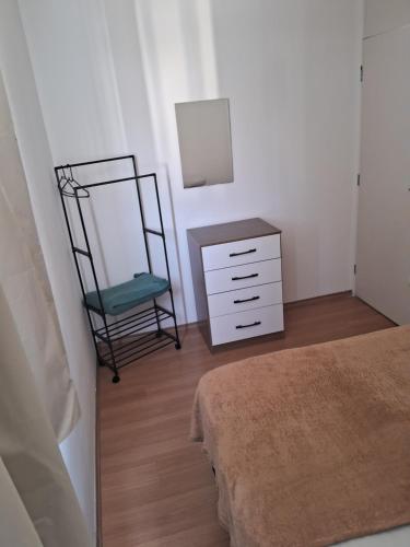 - une chambre avec une commode, un miroir et une chaise dans l'établissement Apto Oeste simples Santa cruz, à Rio de Janeiro