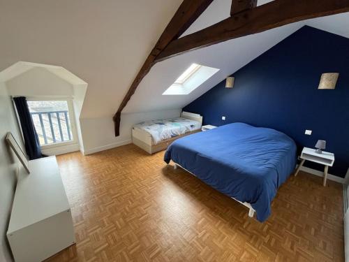 ein Schlafzimmer mit einem Bett und einer blauen Wand in der Unterkunft Grande maison familiale, plage in Pénestin