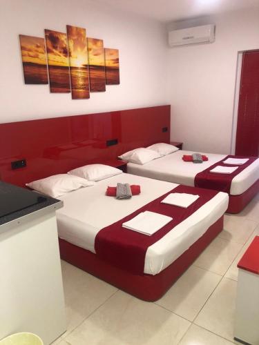 two beds in a room with red and white at Royal Palace in Olympic Beach