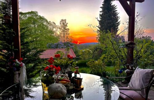 a glass table with flowers on top of a patio at Weil ich es mir wert bin in Seehausen am Staffelsee