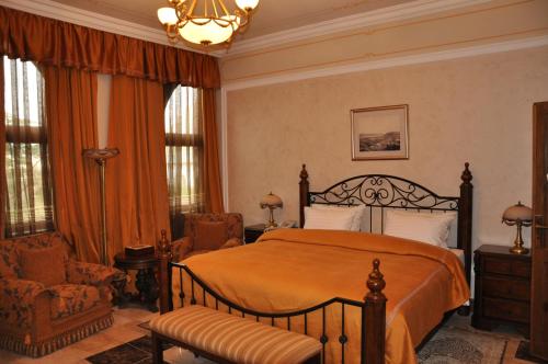 a bedroom with a bed and a chair and windows at Russian Pilgrim Residence in Sowayma