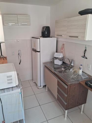 a small kitchen with a refrigerator and a sink at Apto Oeste simples Santa cruz in Santa Cruz