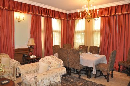 a dining room with red curtains and a table and chairs at Russian Pilgrim Residence in Sowayma