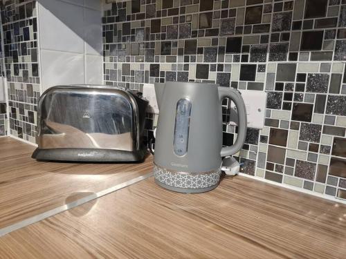einem Toaster, der auf einer Theke neben einem Toaster sitzt in der Unterkunft Stylish Apartment near Tower Bridge in London