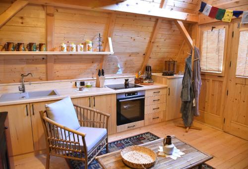 una cucina con lavandino e tavolo in una cabina di Glamping and wellness cottage Salvus a Lendava