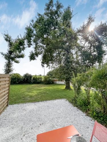 a tree and a bench in front of a yard at Duplex au vert près de Royan - Appartement 4 in Médis