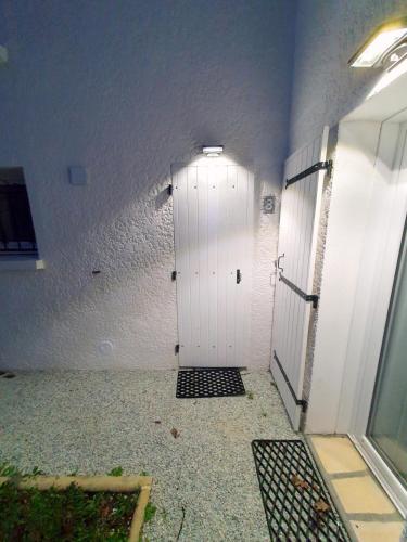 a hallway with a white door in a building at Duplex au vert près de Royan - Appartement 4 in Médis
