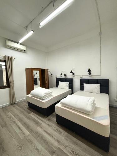 two beds sitting in a room with at Barn1920s Hostel in Vientiane