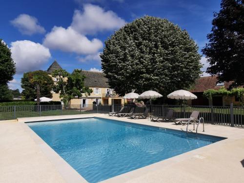 une piscine avec chaises et parasols dans l'établissement Domaine Jolidetour climatisé, piscine et tennis privés, à Saint-Crépin-et-Carlucet