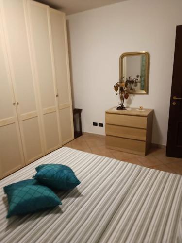 a bedroom with a bed with two pillows and a mirror at Teddy House in Porcari