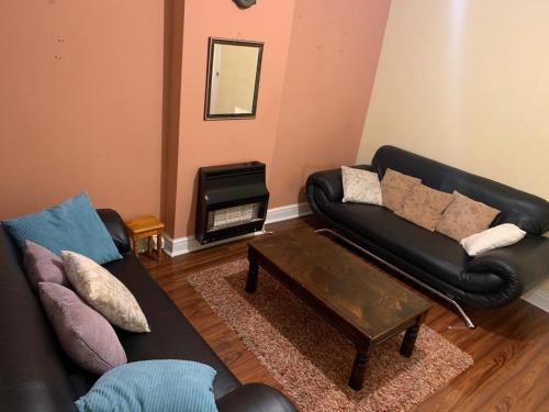 Una sala de estar con un sofá y una mesa de café. en Nice Double room lenton 1, en Nottingham