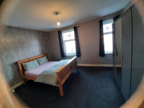 Un dormitorio con una cama y dos ventanas. en Nice Double room lenton 1, en Nottingham