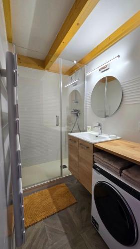 une salle de bain avec une douche, un lavabo et un miroir dans l'établissement Les Saisies Appartement 6 8 personnes en plein centre avec 1 chambre et 2 espaces sous pentes non fermés - Remontées mécaniques à 200 m, à Hauteluce