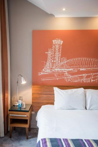a hotel room with a bed and a painting on the wall at The Townhouse Manchester in Manchester