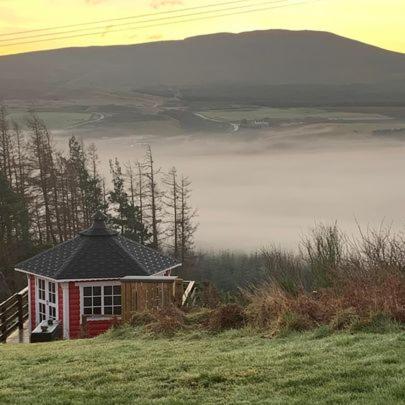 a small house sitting on top of a grassy hill at Daviot Luxury Pods in Inverness