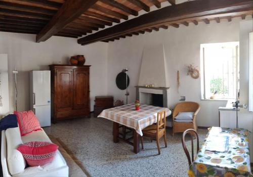 Una sala de estar con una mesa y un refrigerador. en Casa Conti, Riotorto in centro a 7 minuti dal mare, en Riotorto