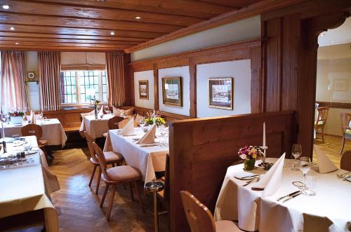 a dining room with white tables and chairs at Hotel Mühle in Binzen