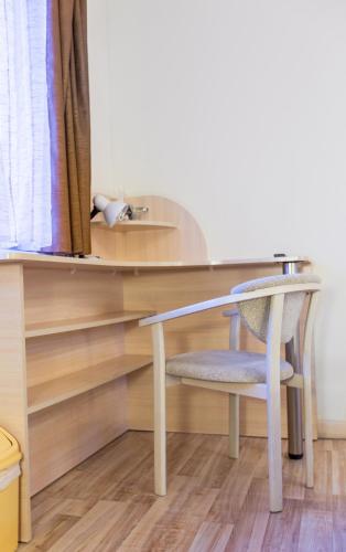 a desk with a chair next to a table at ABC Apartments Business Class in Kyiv