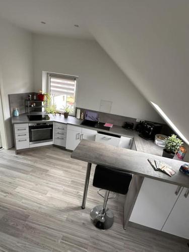 a kitchen with white cabinets and a wooden floor at Panoramablick in Litzendorf in Litzendorf