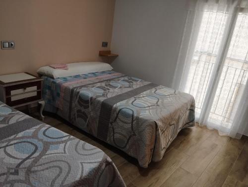 two beds in a room with two windows at Casa Soro Ayna in Ayna
