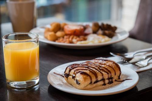 a table with two plates of food and a glass of orange juice at The Townhouse Manchester in Manchester