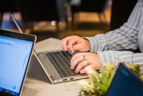 a person is typing on a laptop computer at The Townhouse Manchester in Manchester