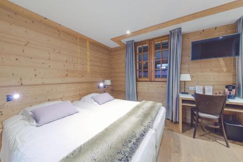 a bedroom with a bed and a desk with a computer at Fleur De Neige Châtel in Châtel