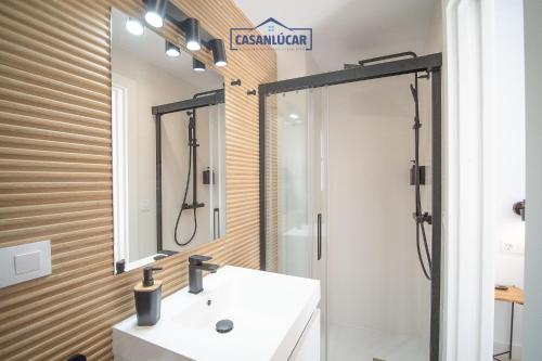 a bathroom with a white sink and a mirror at Sanlucar Centro - Apartamento 5 in Sanlúcar de Barrameda