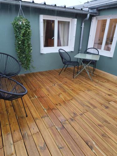 - une terrasse avec des chaises et une table sur du parquet dans l'établissement studio33, à Caen