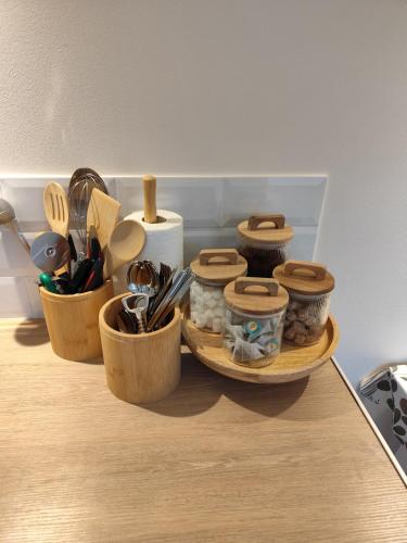 trois conteneurs en bois assis sur un comptoir avec ustensiles dans l'établissement studio33, à Caen