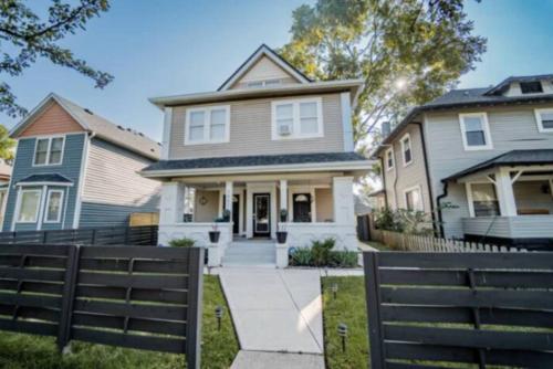 a house with a fence in front of it at Cozy 1BR Getaway - BBQ - Backyard - Pet - Friendly in Indianapolis