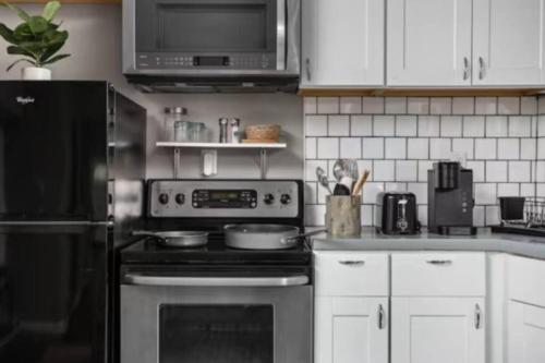a kitchen with a stove and a microwave at Cozy 1BR Getaway - BBQ - Backyard - Pet - Friendly in Indianapolis