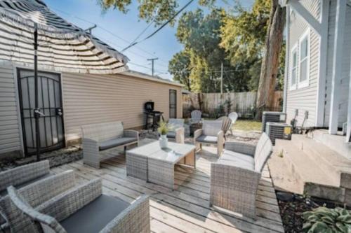 a patio with couches and a table and chairs at Cozy 1BR Getaway - BBQ - Backyard - Pet - Friendly in Indianapolis