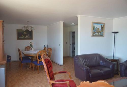 un salon avec une table et un canapé en cuir dans l'établissement Depto frente a la playa en Av del Mar con piscina Se permiten mascotas Mac04, à La Serena