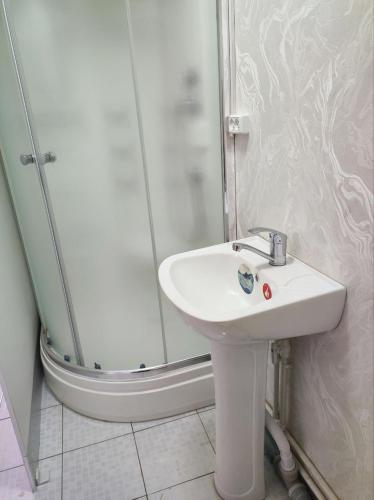 a bathroom with a sink and a shower at Saidjanov Hostel in Bukhara